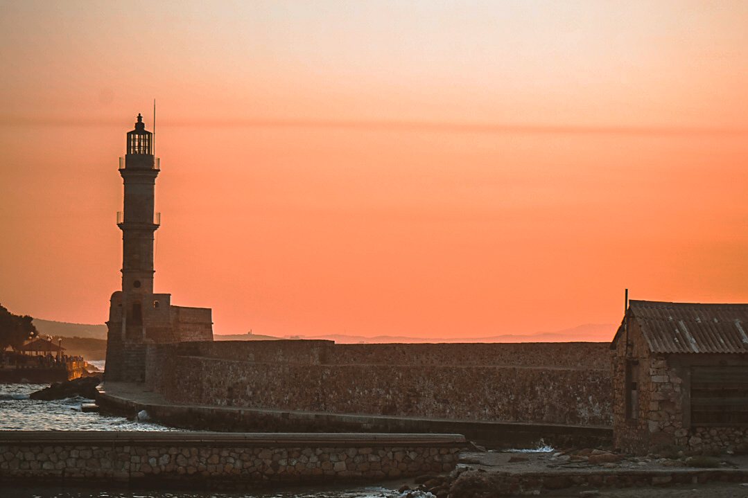 The Venetian lighthouse at Chania harbour silhouetted against a sunrise sky