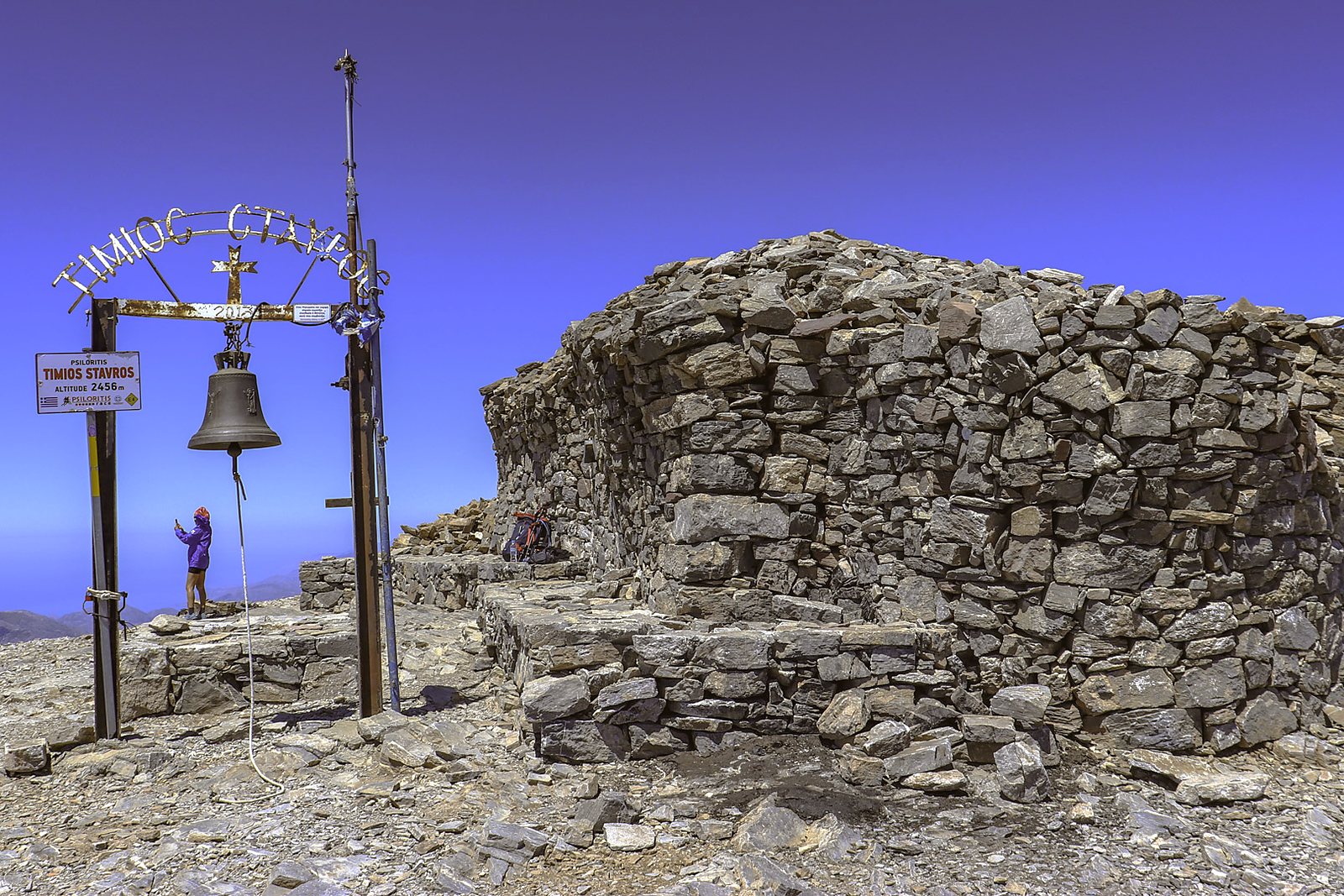 The stone chapel of Timios Stavros at the summit of Psiloritis, with its bell frame against a deep blue sky