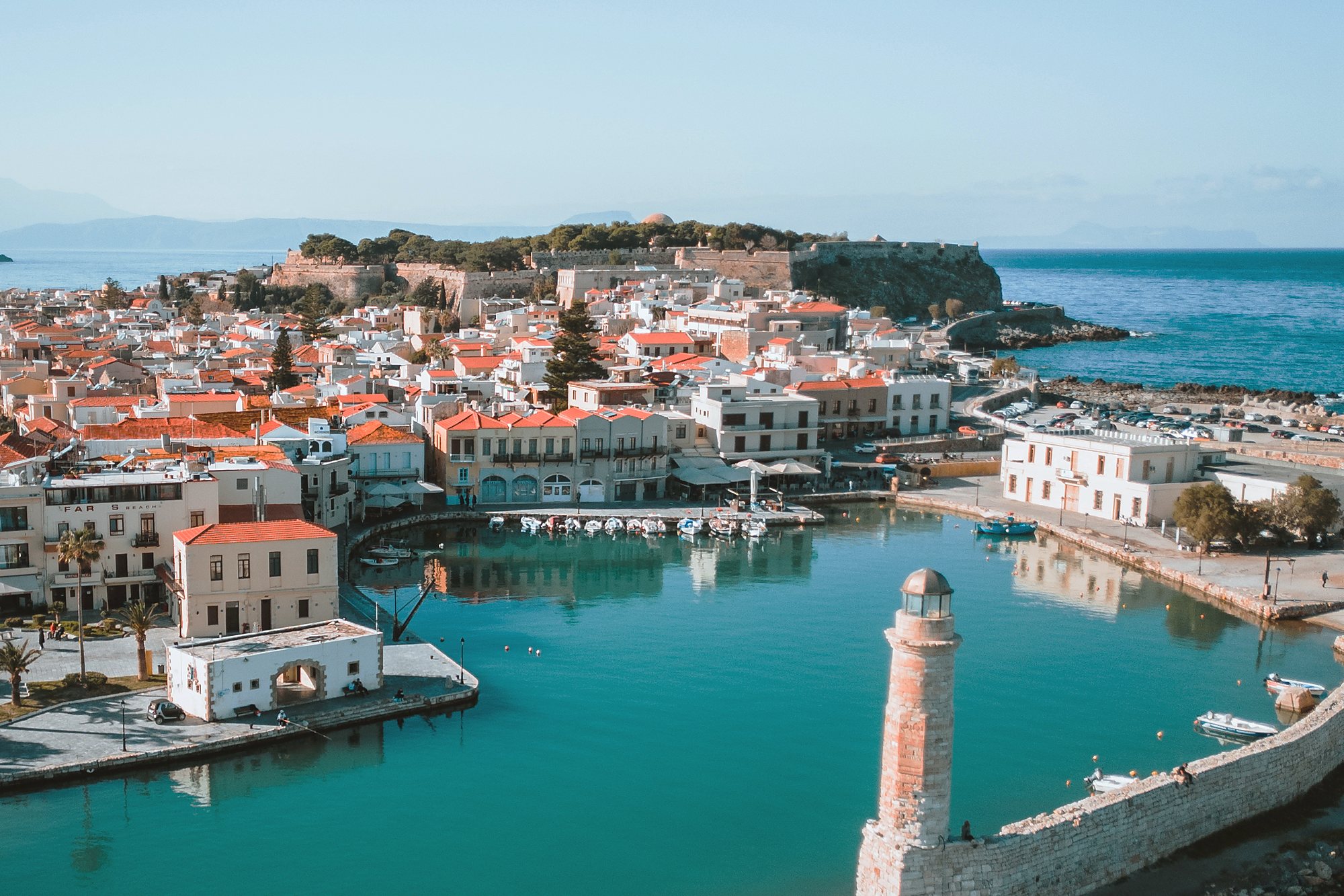 The Venetian harbour of Rethymno with its lighthouse and the Fortezza on the hill behind