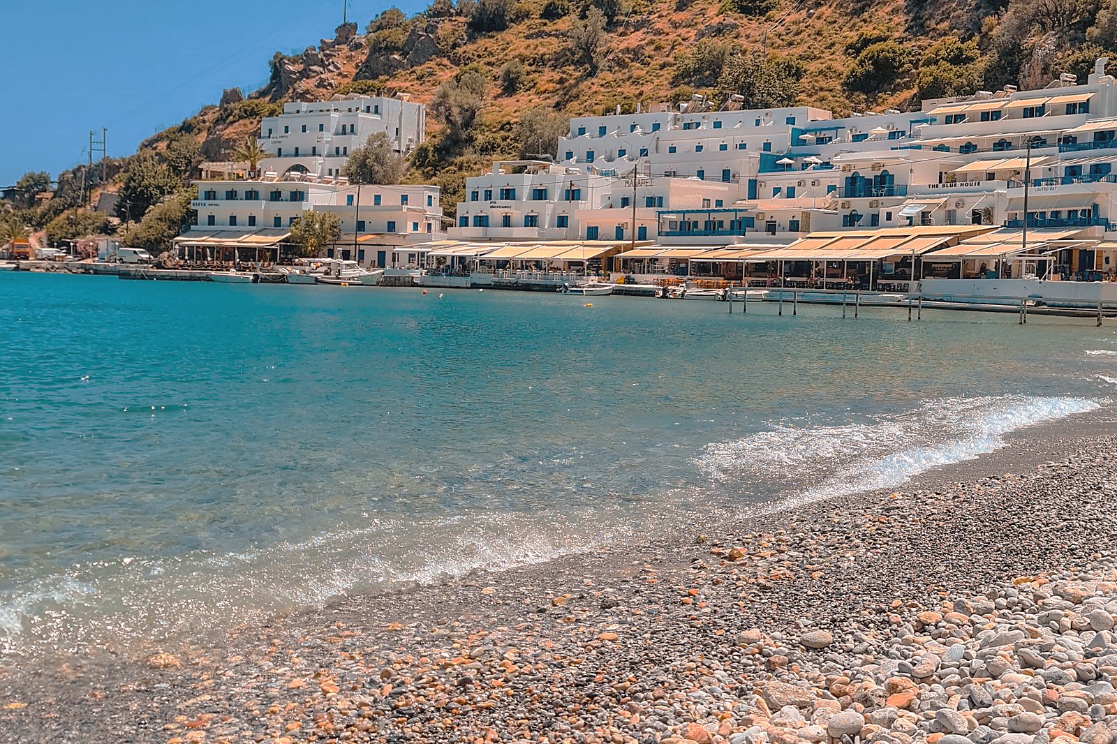 A pebble beach backed by tavernas and white buildings on the Sfakian coast